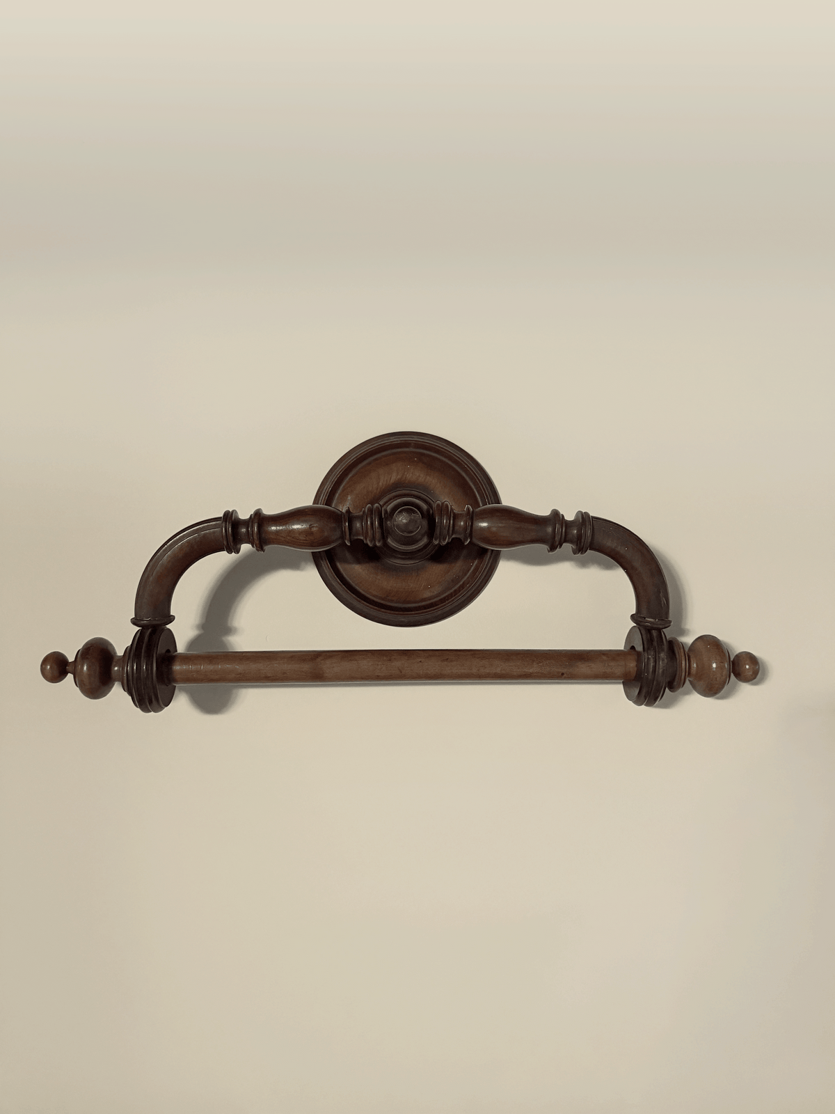 Antique late 19th-century French wall-mounted towel rack made of dark-stained turned wood, featuring a swiveling upper arched bracket with concentric ring details and spherical ball finials over a solid horizontal hanging bar.