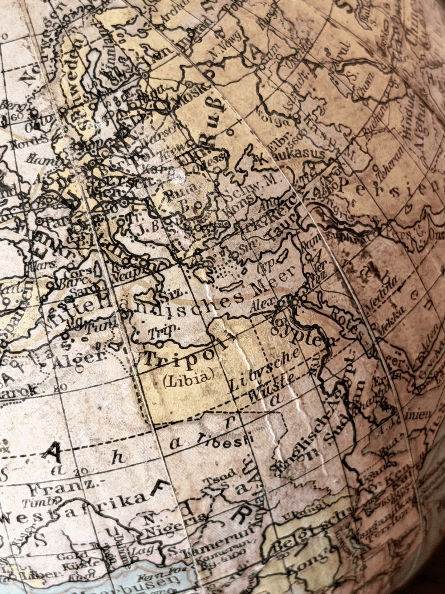 Close-up of interwar cartography on a 1920s German paper globe, showing detailed Weimar-era geography with labels for Leningrad, Scandinavia, and Sowj. Rußl. in a clean serif typography.
