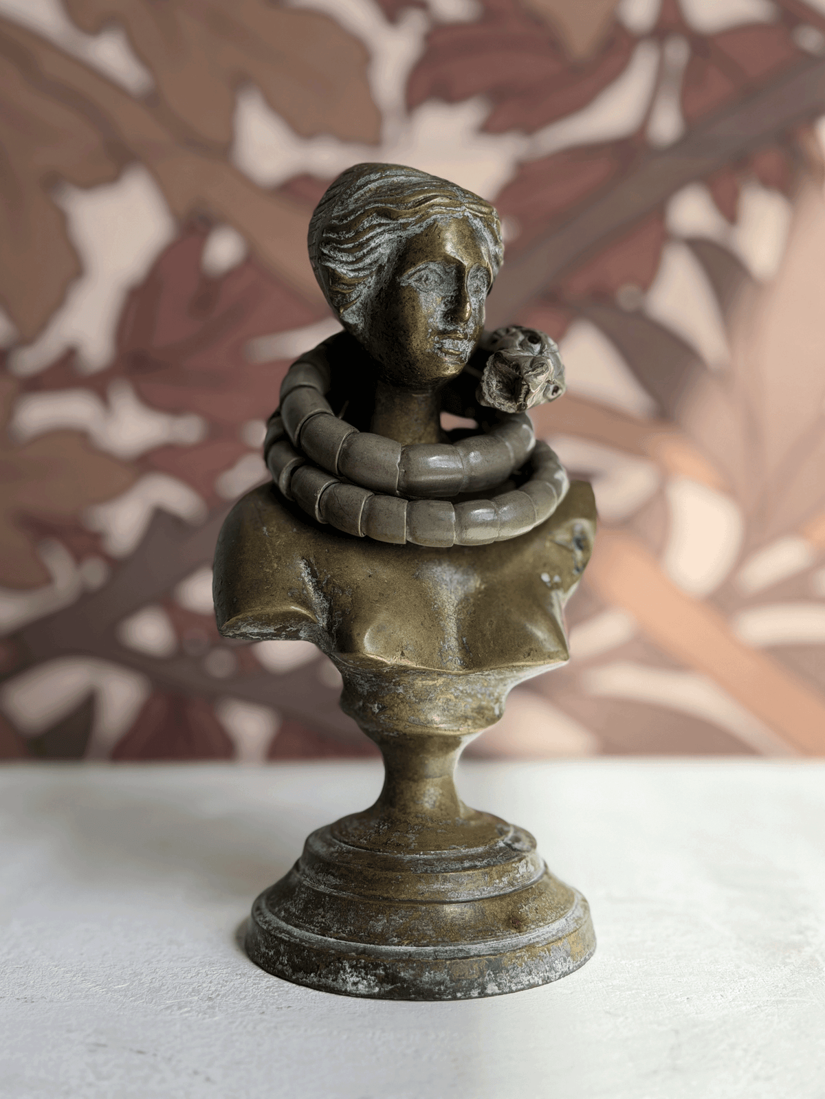 Antique Victorian Vesuvius lava stone snake wrap bracelet draped on the neck of a classical bronze female bust