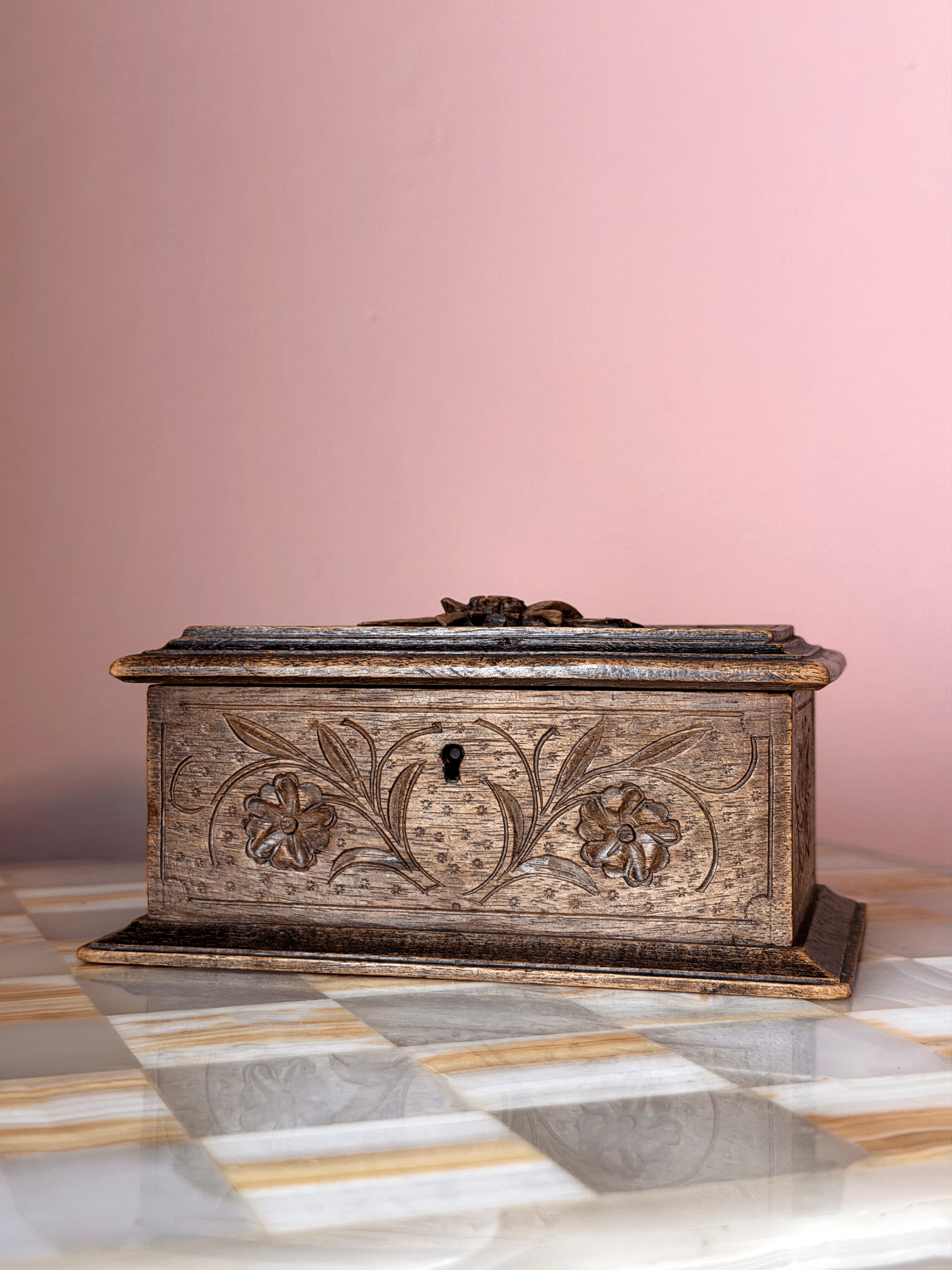 Antique late 19th-century Swiss Alpine folk art wood trinket box, showcasing extensive chip-carving, notched geometric borders, and a tiered molding base