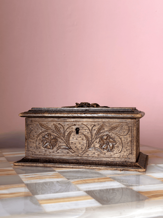 Antique late 19th-century Swiss Alpine folk art wood trinket box, showcasing extensive chip-carving, notched geometric borders, and a tiered molding base