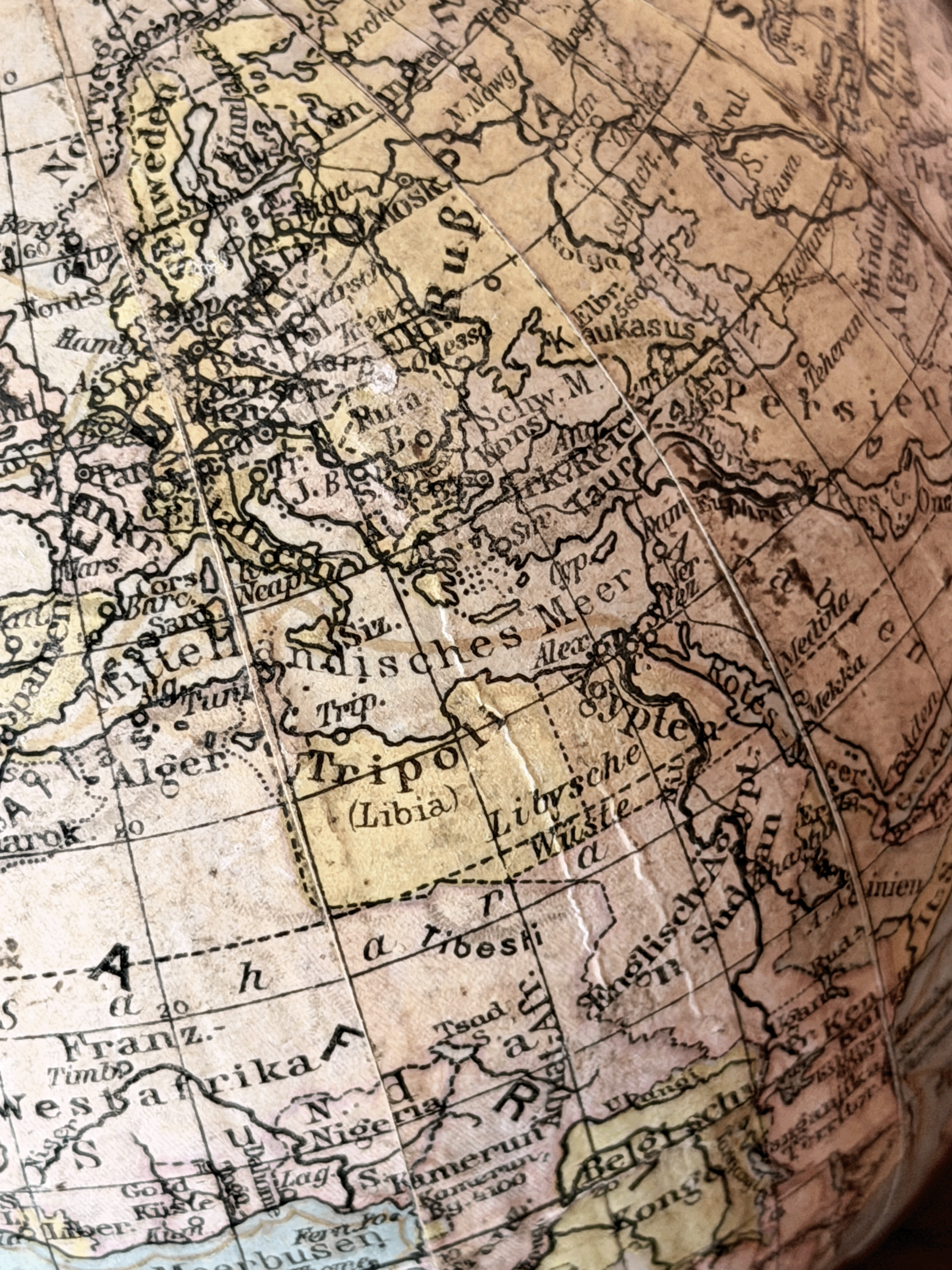 Close-up of interwar cartography on a 1920s German paper globe, showing detailed Weimar-era geography with labels for Leningrad, Scandinavia, and Sowj. Rußl. in a clean serif typography.
