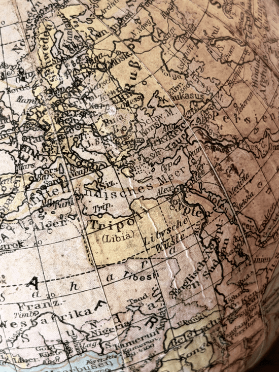 Close-up of interwar cartography on a 1920s German paper globe, showing detailed Weimar-era geography with labels for Leningrad, Scandinavia, and Sowj. Rußl. in a clean serif typography.