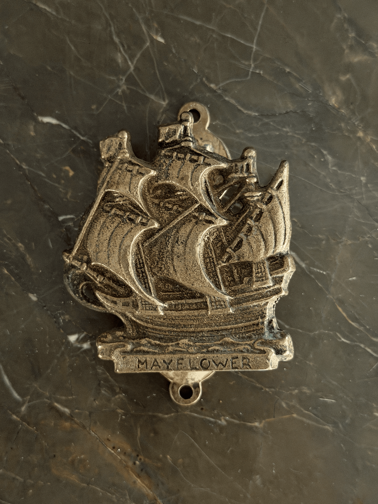 Vintage mid-century solid brass door knocker cast in the shape of the historical Mayflower pilgrim sailing ship, featuring a detailed multi-masted galleon hull with a dark aged patina in the recessed engraving.
