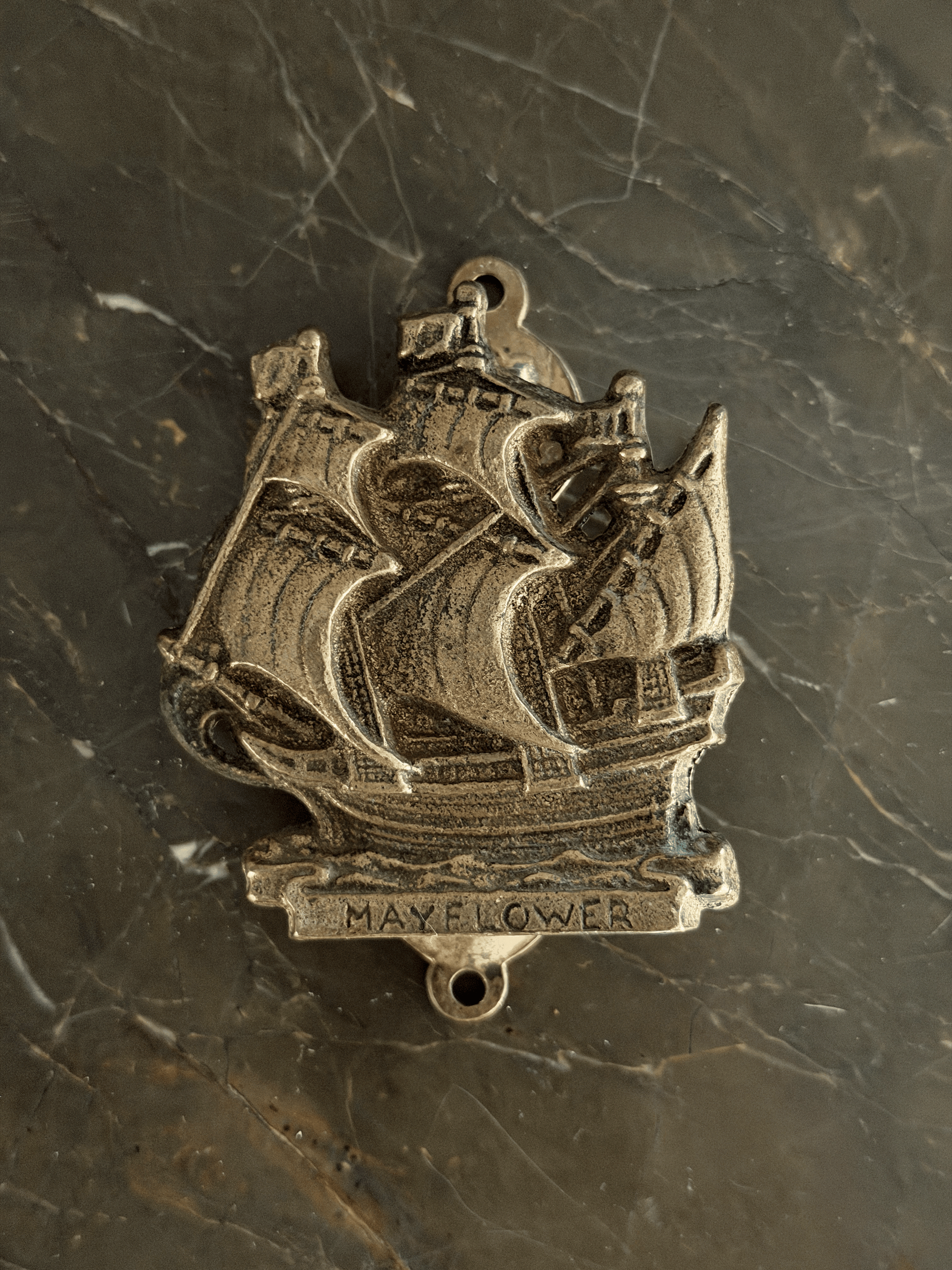 Vintage mid-century solid brass door knocker cast in the shape of the historical Mayflower pilgrim sailing ship, featuring a detailed multi-masted galleon hull with a dark aged patina in the recessed engraving.