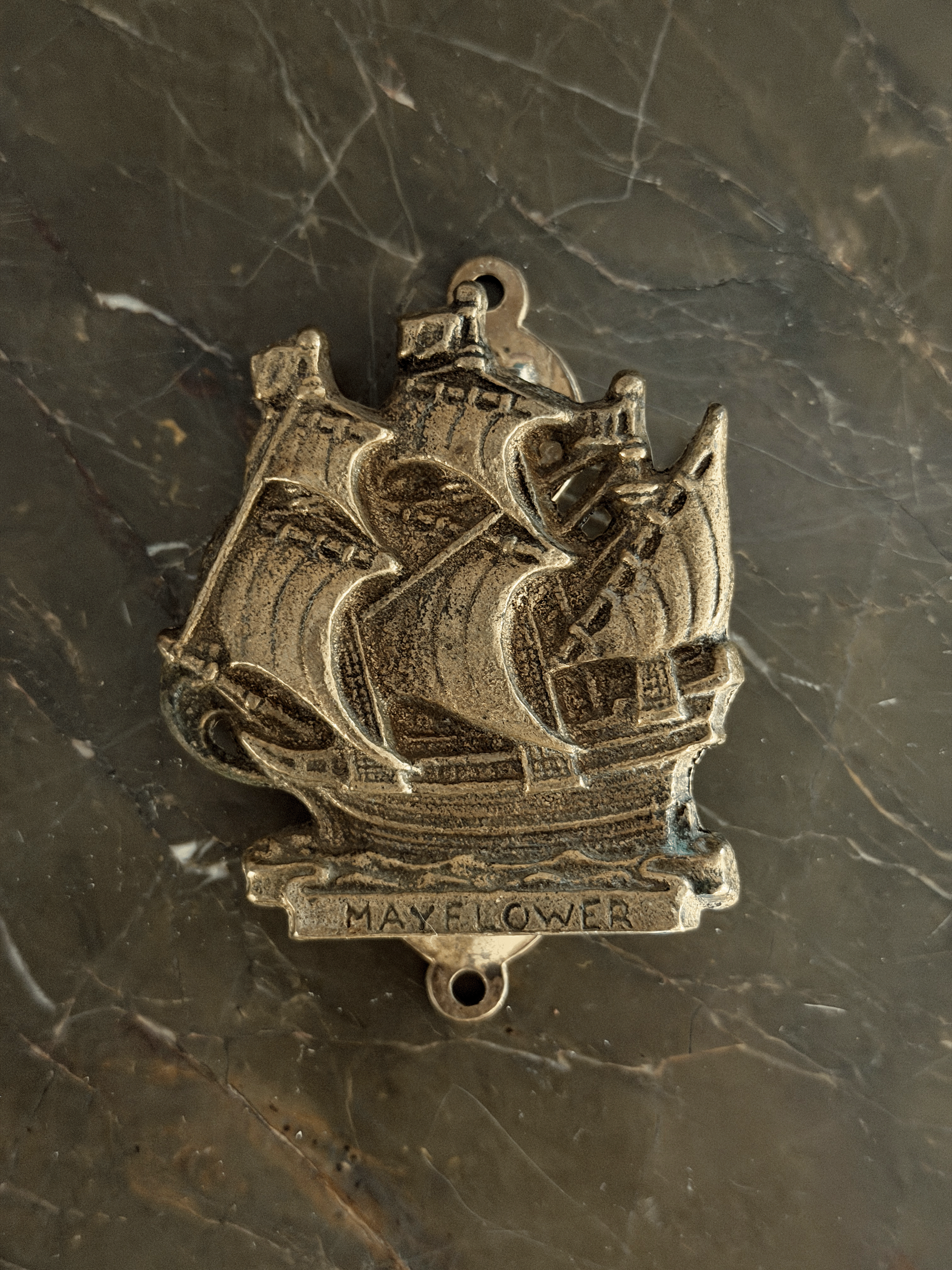 Vintage mid-century solid brass door knocker cast in the shape of the historical Mayflower pilgrim sailing ship, featuring a detailed multi-masted galleon hull with a dark aged patina in the recessed engraving.