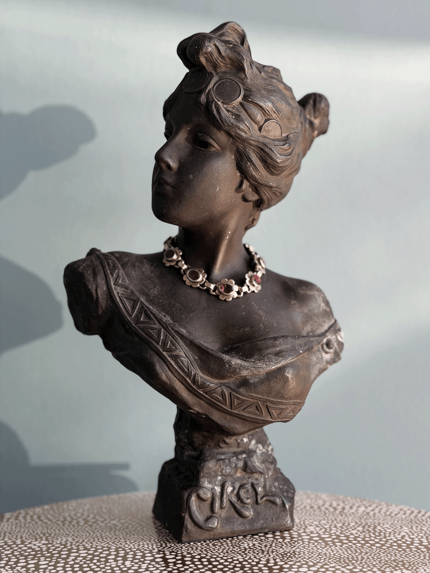 Antique Art Nouveau dark bronze spelter bust sculpture of the Greek goddess Circe with decorative coin headdress and garnet bracelet around neck.