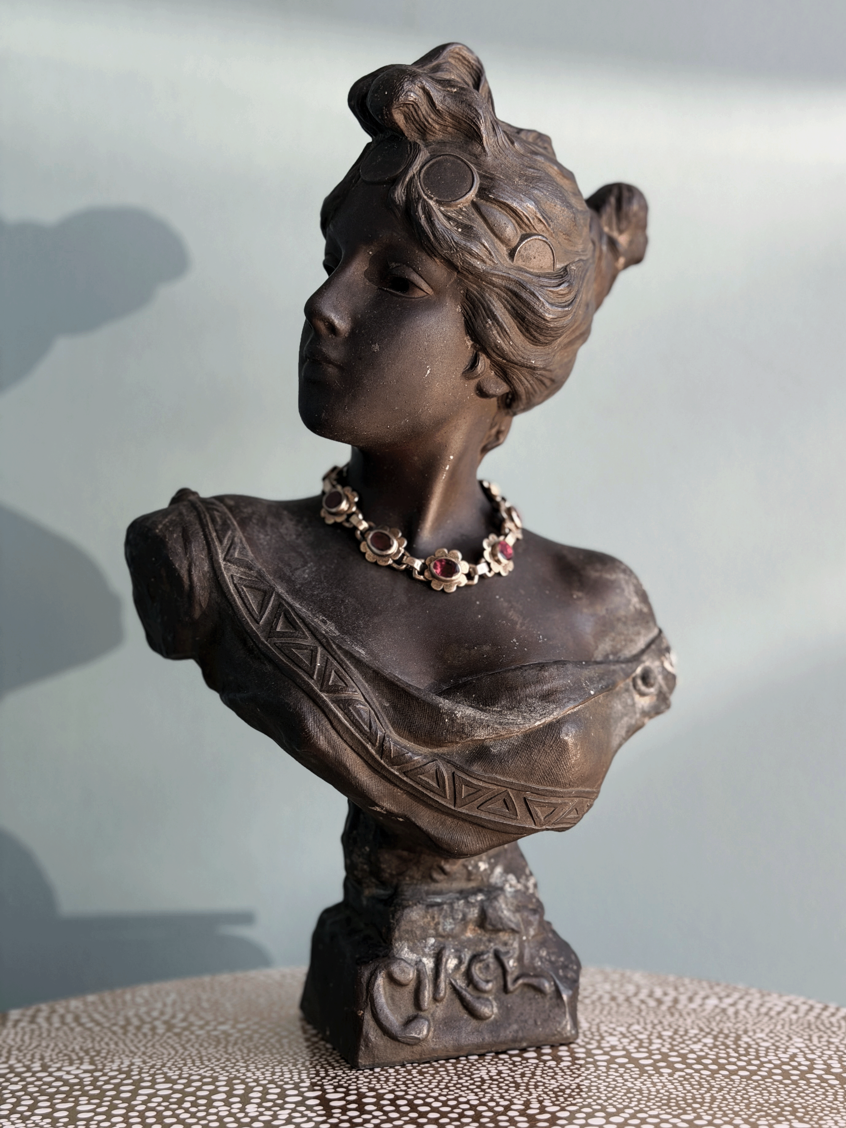 Antique Art Nouveau dark bronze spelter bust sculpture of the Greek goddess Circe with decorative coin headdress and garnet bracelet around neck.