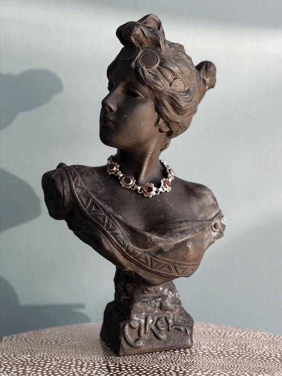 Antique Art Nouveau dark bronze spelter bust sculpture of the Greek goddess Circe with decorative coin headdress and garnet bracelet around neck.