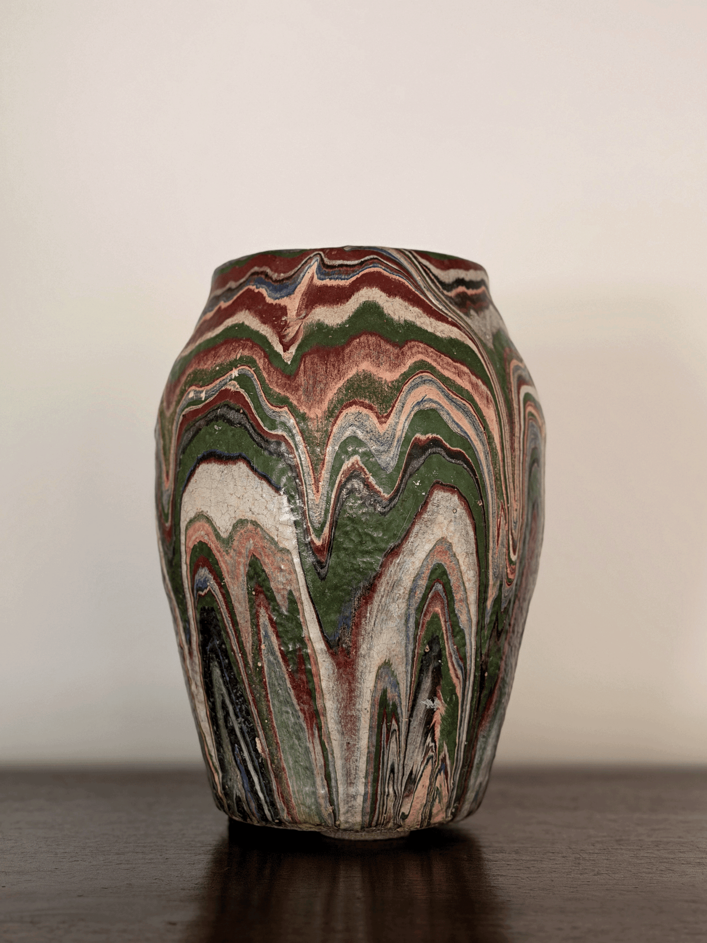Imposing front-view photo of a large 10-inch tall antique Ozark tourist pottery vase featuring heavy, textured, flame-like wavy swirls of blue, rust, green, and cream paint.