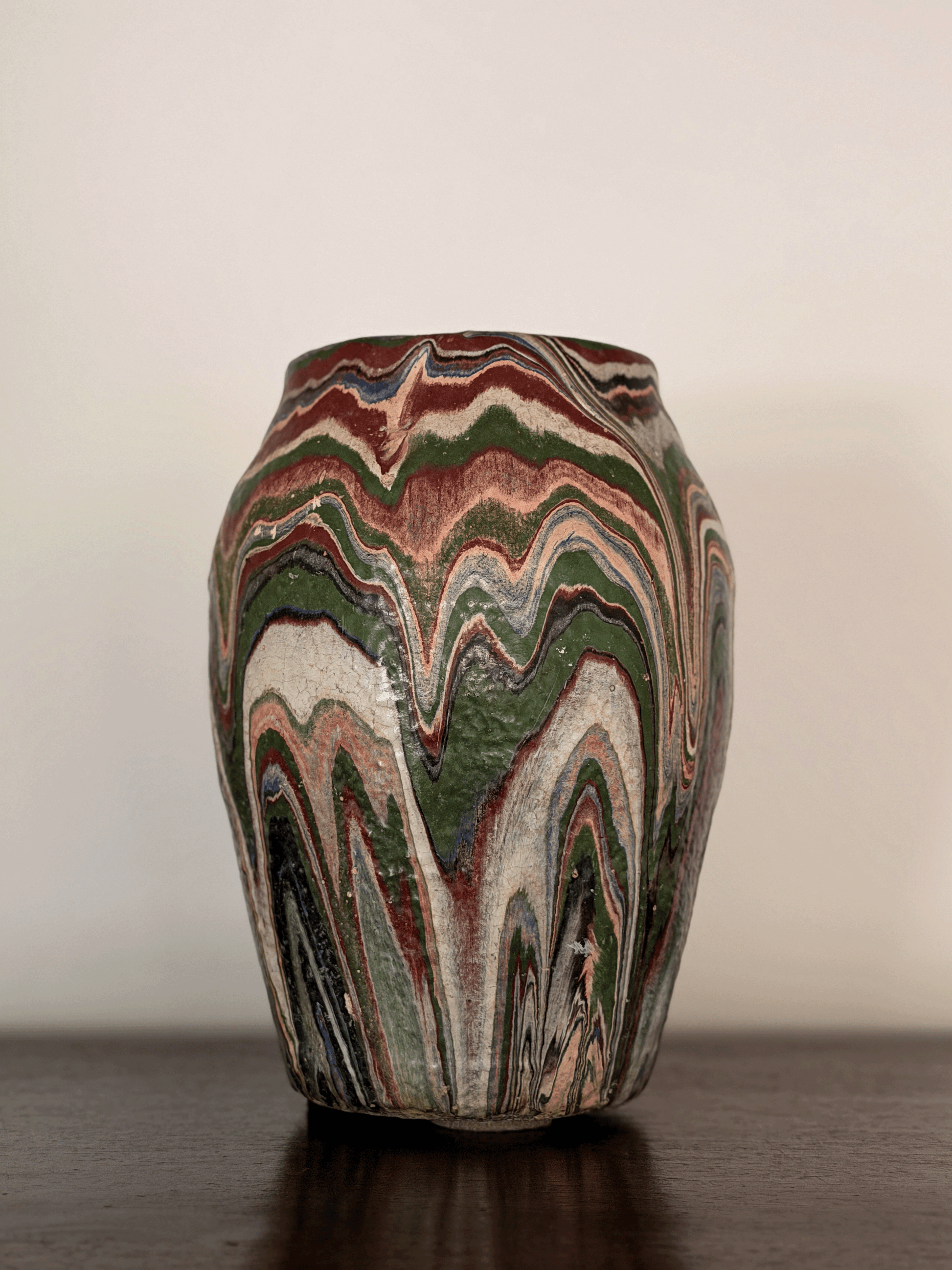 Imposing front-view photo of a large 10-inch tall antique Ozark tourist pottery vase featuring heavy, textured, flame-like wavy swirls of blue, rust, green, and cream paint.