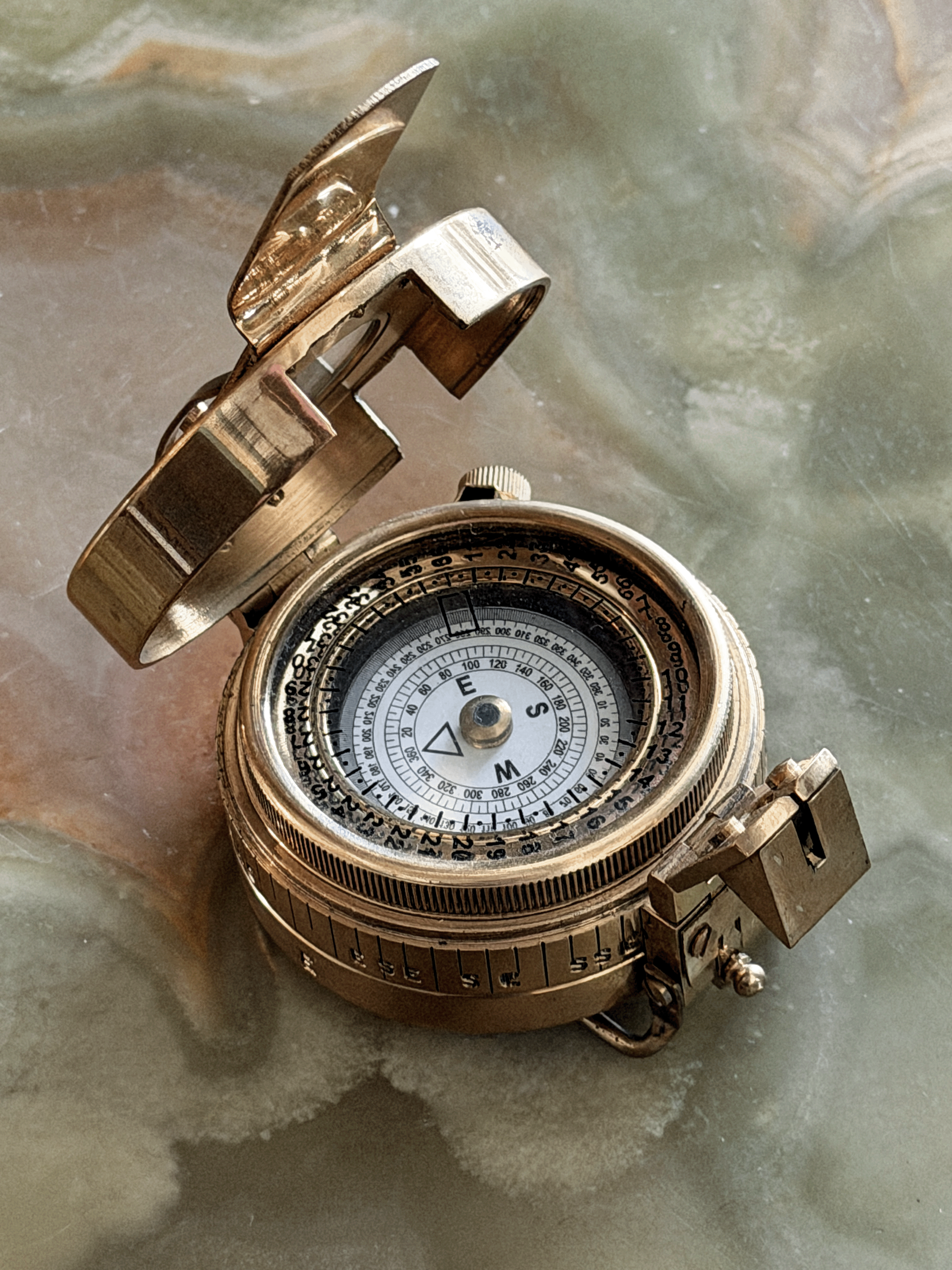 Close up of face on vintage reproduction circular brass military prismatic sighting compass