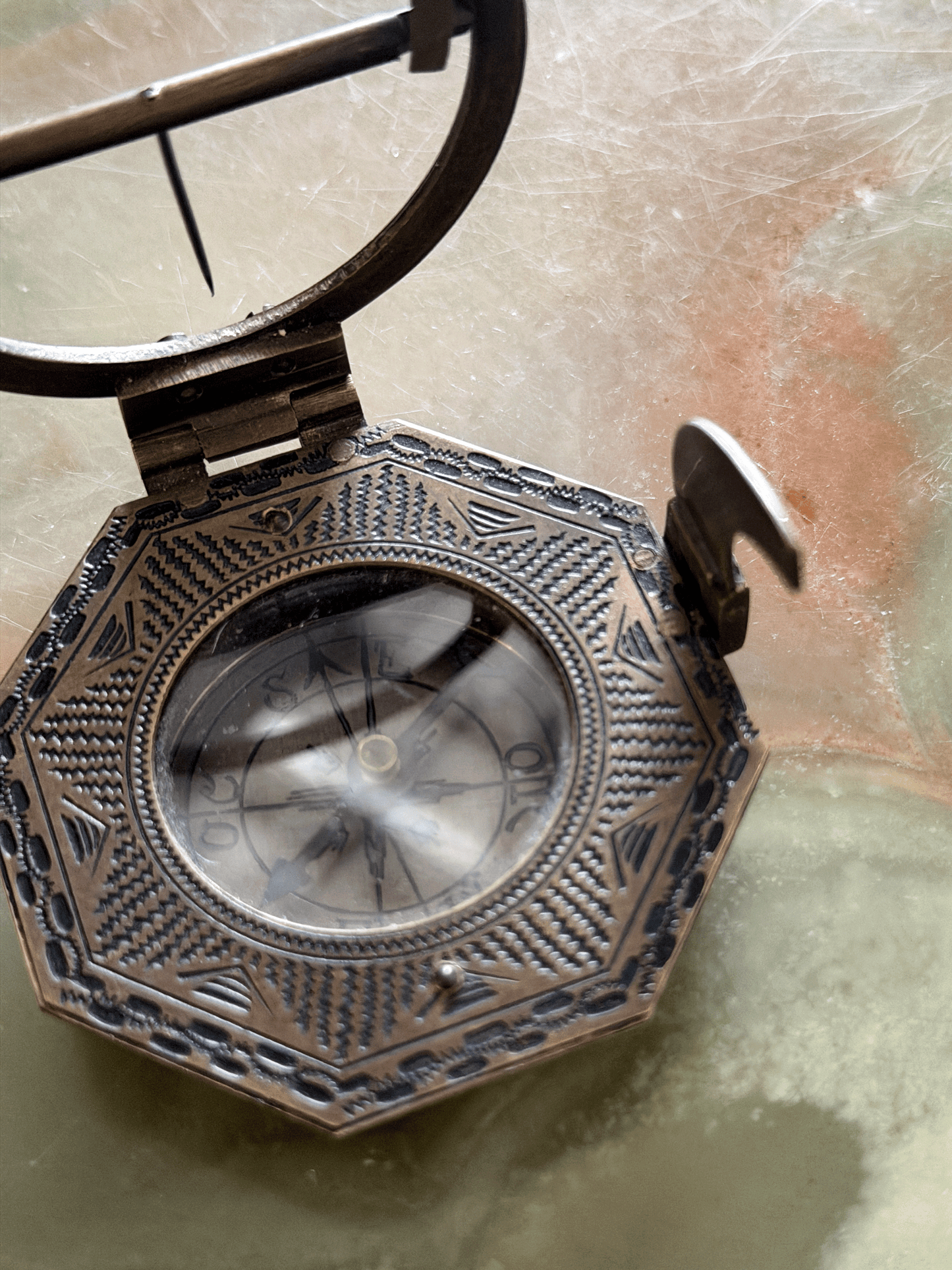Engraved underside of a reproduction brass pocket sundial, replicating an 18th-century German instrument with an Elev. Pol. latitude table for Augsburg, Paris, Cracau, and Liège alongside the maker signature Schretegger.