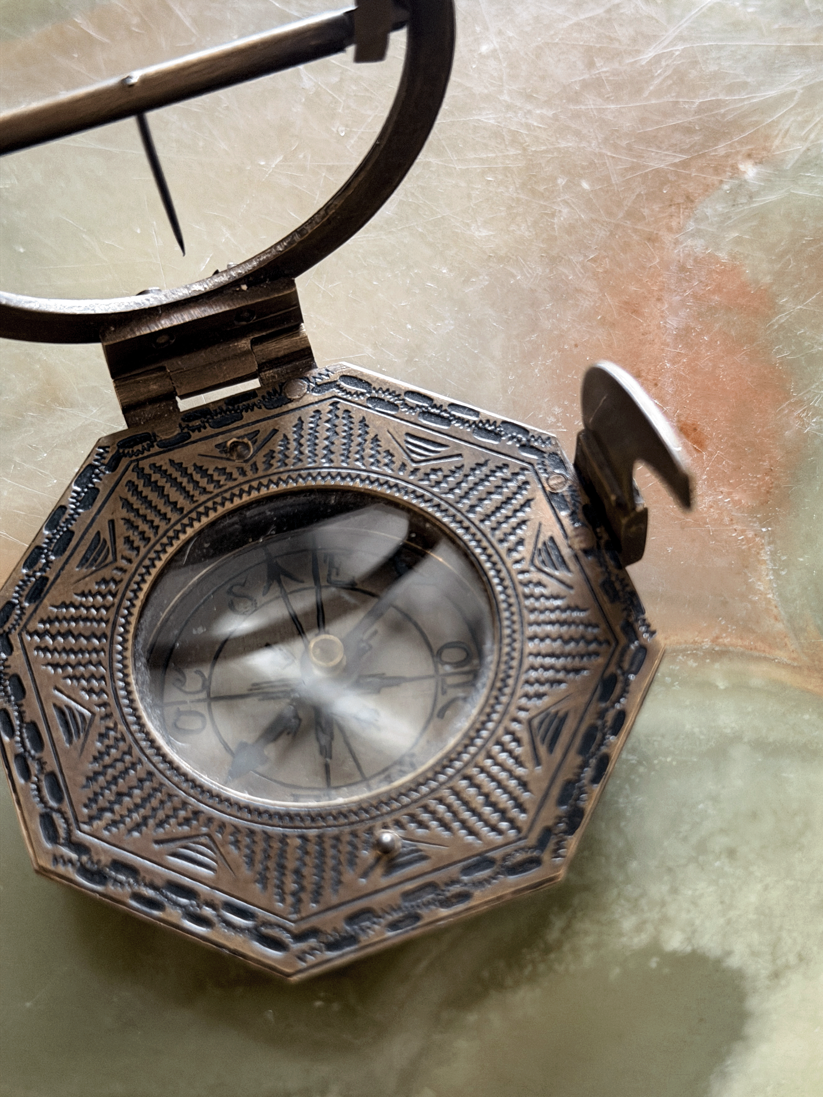 Engraved underside of a reproduction brass pocket sundial, replicating an 18th-century German instrument with an Elev. Pol. latitude table for Augsburg, Paris, Cracau, and Liège alongside the maker signature Schretegger.