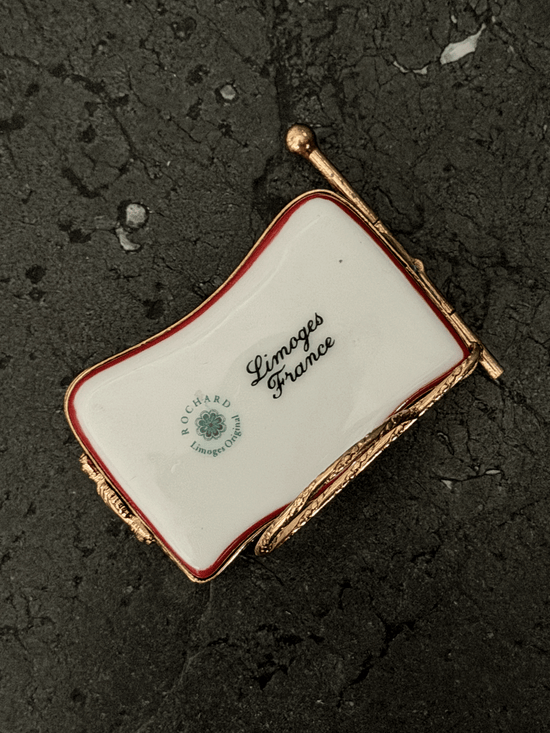Underside base view of a wavy hand-painted Rochard porcelain trinket box, showing a bright white glazed surface stamped with the green circular ROCHARD Limoges Original floral seal and black cursive Limoges France script.