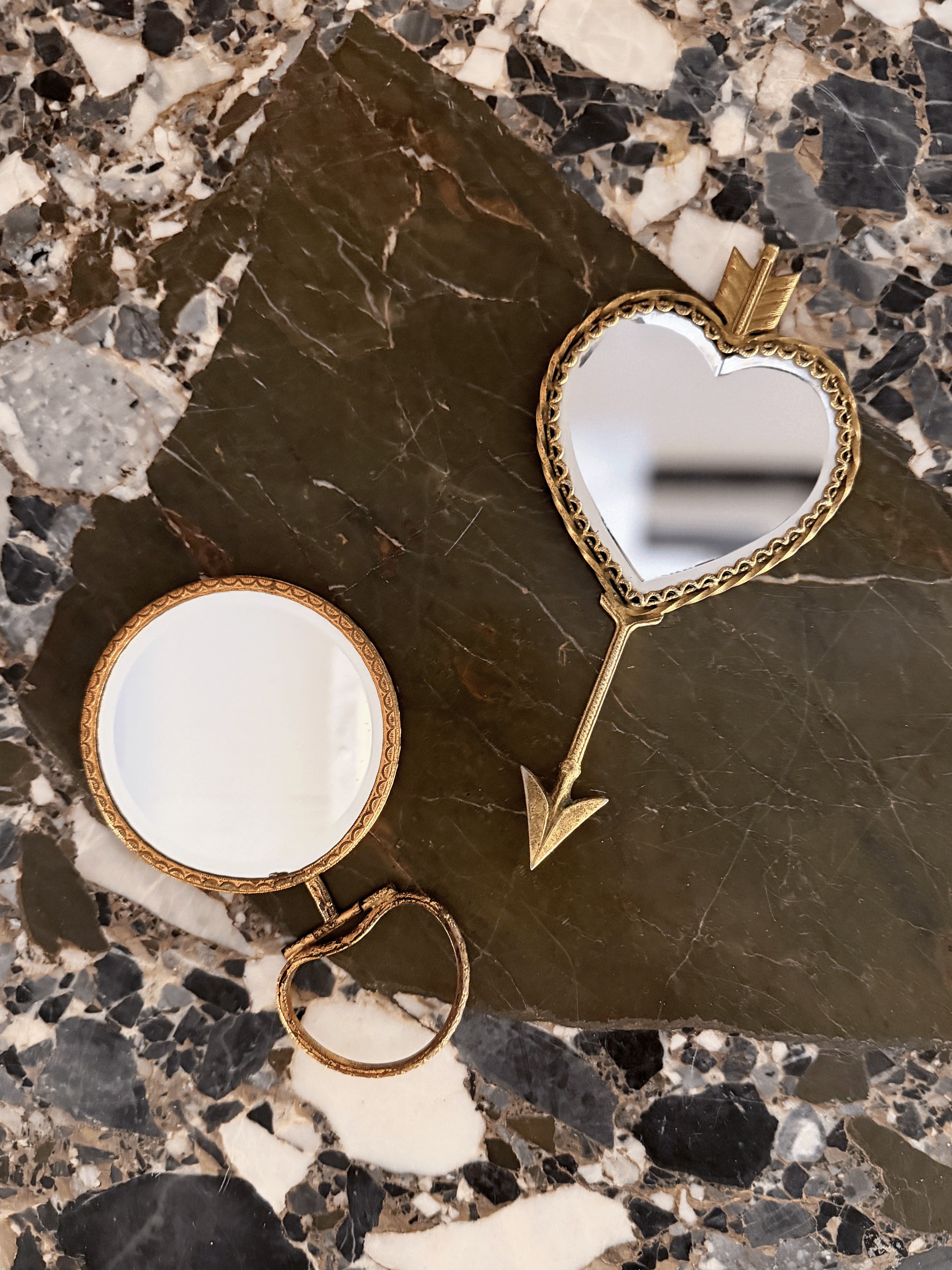 two vintage handheld mirrors, his and hers, with brass frames and intricate detailing